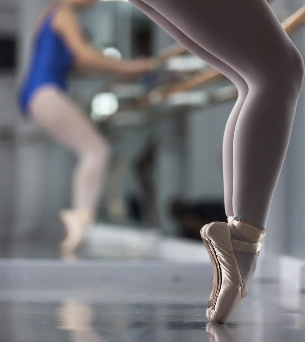 Detalle de zapatillas de punta durante un ejercicio de ballet clásico