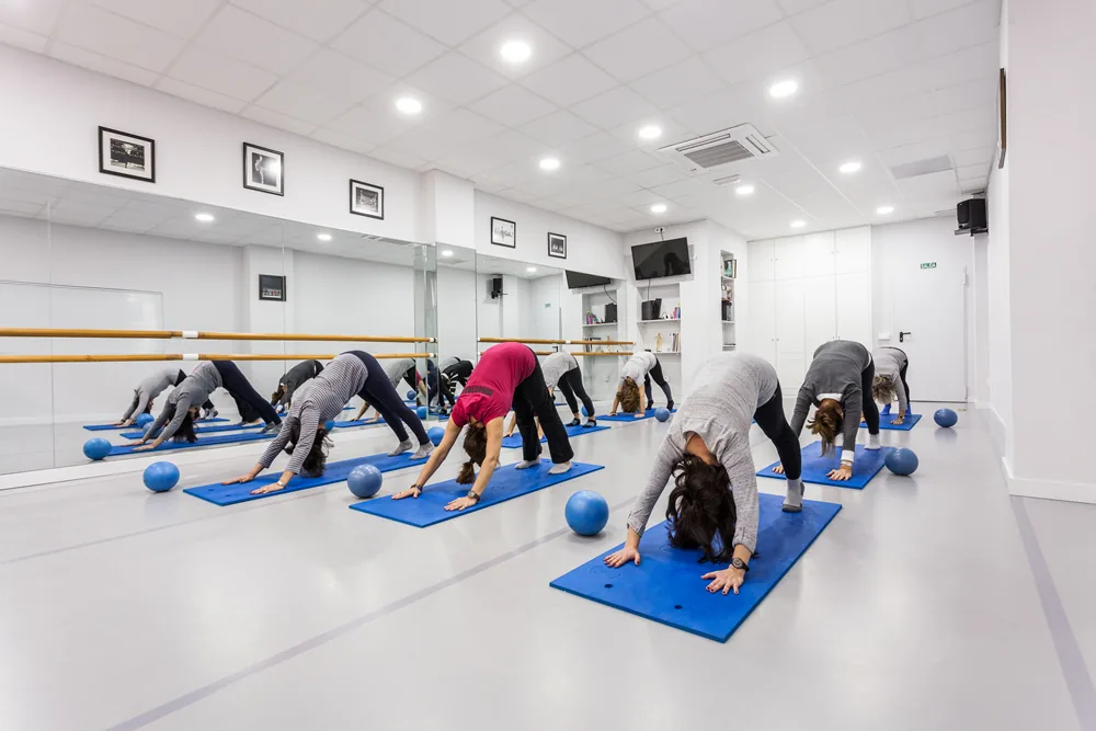 Sesión de Pilates en colchoneta con material de la escuela