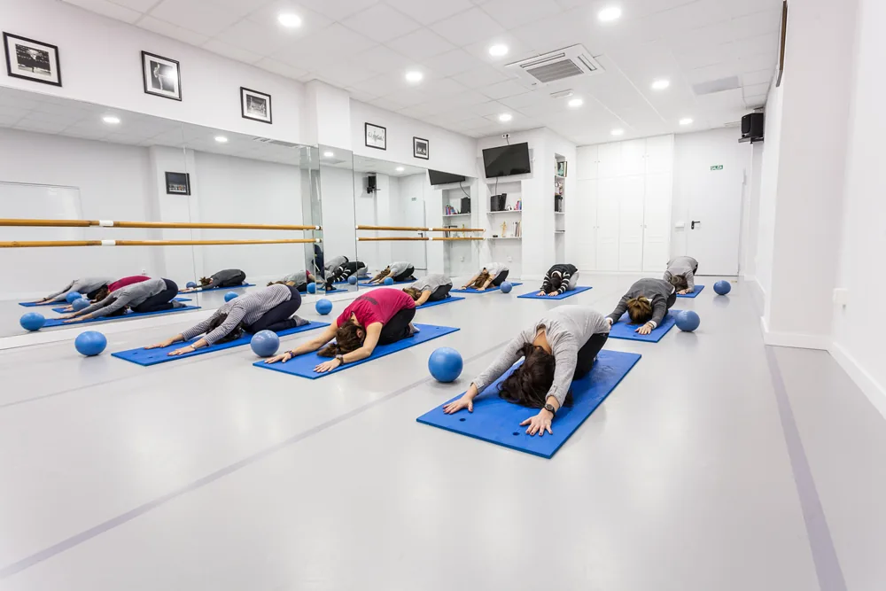 Grupo de Pilates durante un ejercicio de suelo
